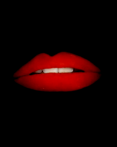 Gif of the opening scene of Rocky Horror Picture Show, where Patricia Quinn's lips that have red lipstick on lip-sync to the song "Science Friction/Double Feature"